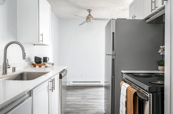 A modern kitchen with a stainless steel refrigerator and a stove top oven.